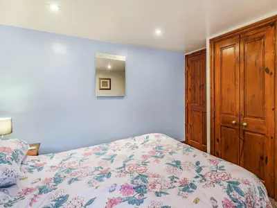 a bedroom with a bed with a floral bedspread at The Granary in Poulton le Fylde