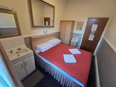 a small room with a bed and a sink at Westholme Hotel in Blackpool