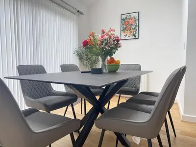 a dining room table with chairs and a vase of flowers at The Ravens Inn, 4 - Bed, Sleeps 6, Pets Welcome in Ulverston