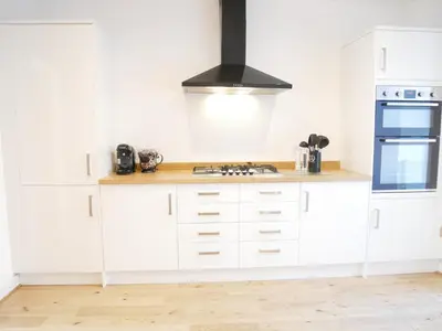 a kitchen with white cabinets and a stove top oven at The Ravens Inn, 4 - Bed, Sleeps 6, Pets Welcome in Ulverston