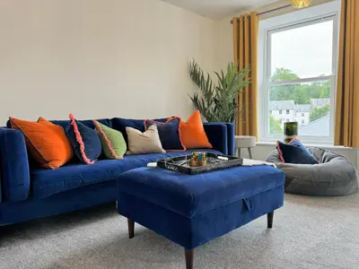 a living room with a blue couch and a blue ottoman at The Ravens Inn, 4 - Bed, Sleeps 6, Pets Welcome in Ulverston
