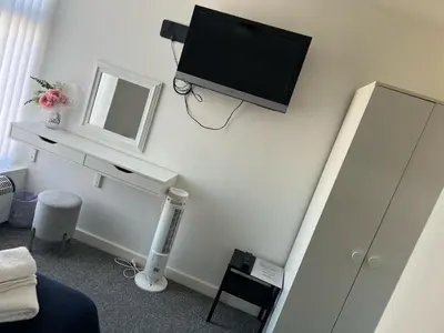 a room with a tv on a wall with a mirror at Alexandra Hotel in Blackpool
