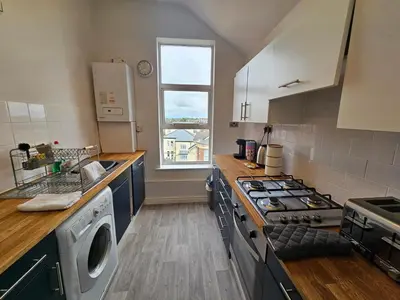 a kitchen with a stove top oven next to a window at Avondale,2 bed lakeside on the Promenade, free parking & wifi in Southport