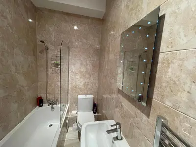 a bathroom with a tub and a toilet and a sink at Avondale,2 bed lakeside on the Promenade, free parking & wifi in Southport
