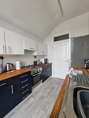 a kitchen with white cabinets and a sink at Avondale,2 bed lakeside on the Promenade, free parking & wifi in Southport