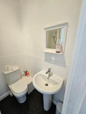a white bathroom with a toilet and a sink at Avondale,2 bed lakeside on the Promenade, free parking & wifi in Southport