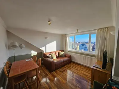 a living room with a couch and a table at Avondale,2 bed lakeside on the Promenade, free parking & wifi in Southport