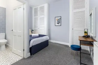 a bedroom with a bed and a desk and a toilet at Arkles House - Air Host & Stay - Anfield in Liverpool
