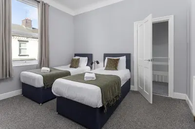 two beds in a room with a window at Arkles House - Air Host & Stay - Anfield in Liverpool
