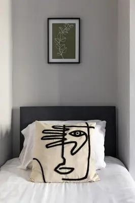 a bed with a pillow with a face on it at Arkles House - Air Host & Stay - Anfield in Liverpool