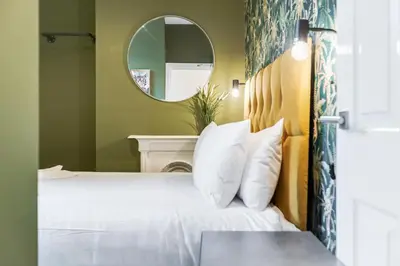 a bedroom with a white bed and a mirror at Queen Street Apartments by Sasco in Blackpool