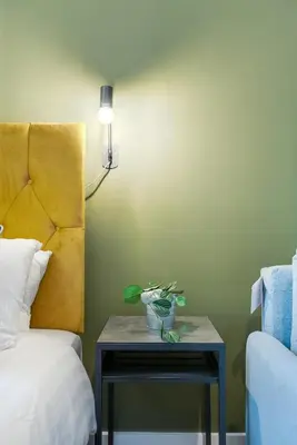 a table with a vase on it next to a bed at Queen Street Apartments by Sasco in Blackpool