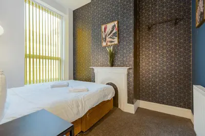 a small bedroom with a bed and a fireplace at Queen Street Apartments by Sasco in Blackpool