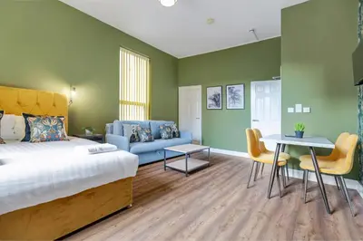 a bedroom with a bed and a couch and a table at Queen Street Apartments by Sasco in Blackpool