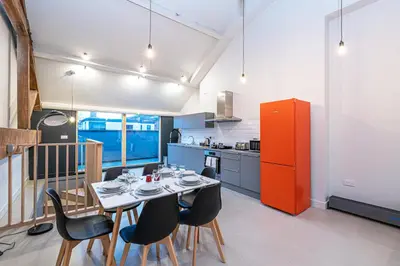 a dining room with a table and chairs in a kitchen at Carriage Works by Guestz in Preston