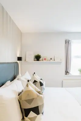 a bedroom with a bed with black and white pillows at Prime Suites Lytham in Lytham St Annes
