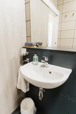 a white sink in a bathroom with a mirror at Prime Suites Lytham in Lytham St Annes