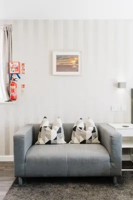 a grey couch with pillows in a living room at Prime Suites Lytham in Lytham St Annes