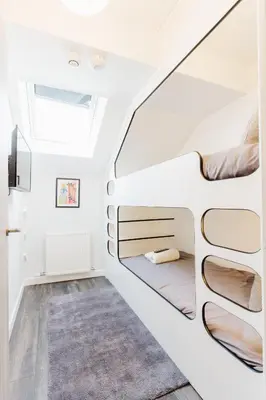 a bedroom with two beds in a white room at Prime Suites Lytham in Lytham St Annes