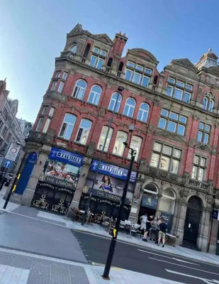a large red brick building on a city street at 4 bed city centre flat in Liverpool