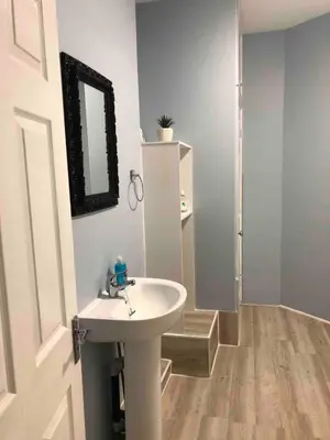 a bathroom with a white sink and a mirror at 4 bed city centre flat in Liverpool