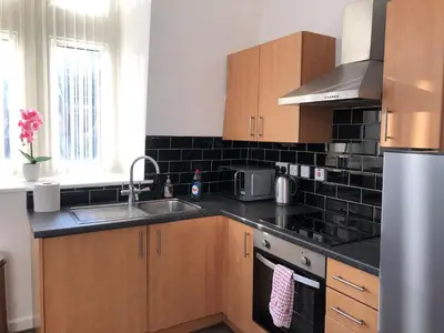 a kitchen with a sink and a stove top oven at 4 bed city centre flat in Liverpool