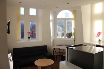 a living room with a black couch and a table at 4 bed city centre flat in Liverpool