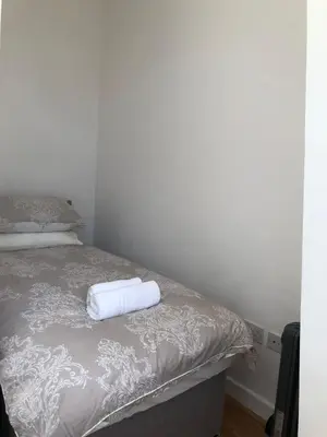 a bed with a white towel on top of it at 4 bed city centre flat in Liverpool