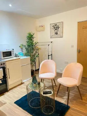 a living room with two chairs and a table at CityNights Studios with Free Parking in Liverpool