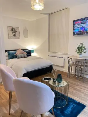 a bedroom with a bed and a table and chairs at CityNights Studios with Free Parking in Liverpool