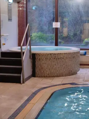 a swimming pool with a hot tub next to a window at Gorgeous Cottage near Cartmel with FREE SPA Access in Holker