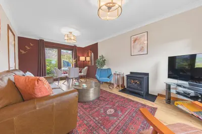 a living room with a couch and a television at Gorgeous Cottage near Cartmel with FREE SPA Access in Holker