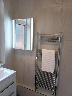 a bathroom with a towel rack and a mirror at St Annes Lodge Apartments, Lytham St Annes in Lytham St Annes