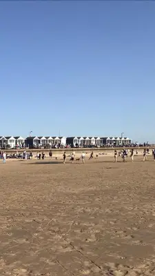 a group of people sitting on the beach at St Annes Lodge Apartments, Lytham St Annes in Lytham St Annes