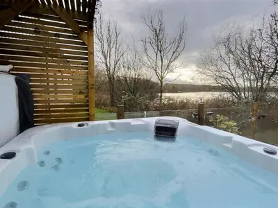 a jacuzzi tub with a view of a lake at Coniston View 7 in Warton