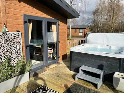 a hot tub sitting on a deck next to a building at Coniston View 7 in Warton