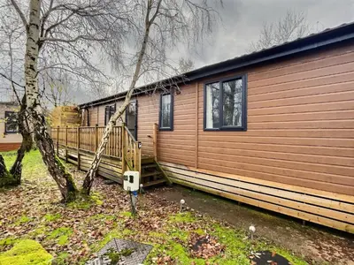 a small house with a tree next to it at Coniston View 7 in Warton