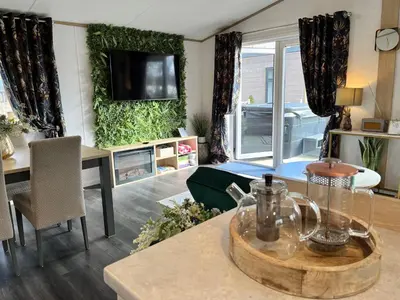 a living room with a table and a tv on the wall at Coniston View 7 in Warton
