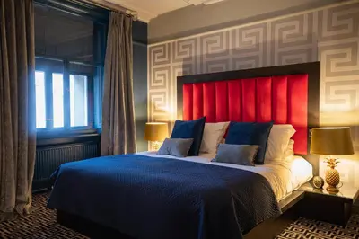 a bedroom with a large bed with a red headboard at 62 Castle Street Hotel in Liverpool