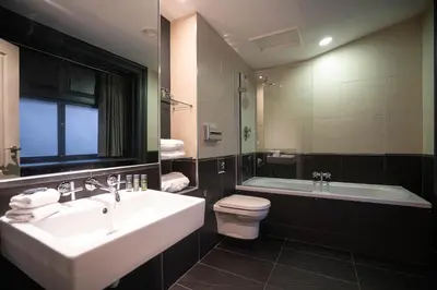 a bathroom with a sink and a tub and a toilet at 62 Castle Street Hotel in Liverpool