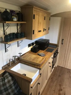 a kitchen with a sink and wooden cabinets at Woody's Retreat in Bolton by Bowland