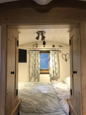 a bedroom with a large bed with a window at Woody's Retreat in Bolton by Bowland