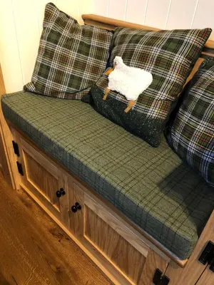 a couch with two pillows and a stuffed sheep on it at Woody's Retreat in Bolton by Bowland