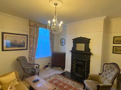 a living room with a fireplace and a chandelier at Number 19 - Victorian Town House in Clitheroe