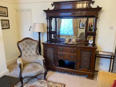 a room with a dresser and a chair and a mirror at Number 19 - Victorian Town House in Clitheroe