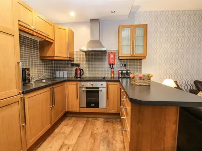 a kitchen with wooden cabinets and a black counter top at Bella Vita in Southport