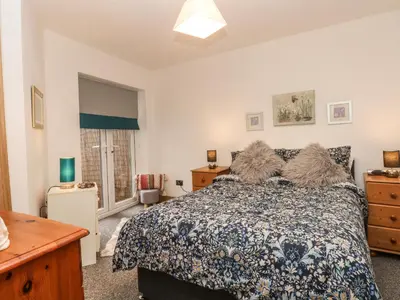 a bedroom with a bed and a dresser and a window at Bella Vita in Southport