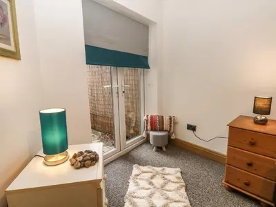 a bedroom with a window and a dresser with a lamp at Bella Vita in Southport