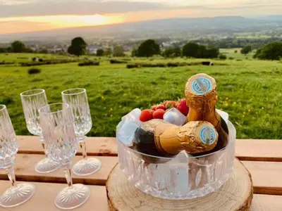 a table with wine glasses and a bowl of food at Ribble Valley Retreat in Langho