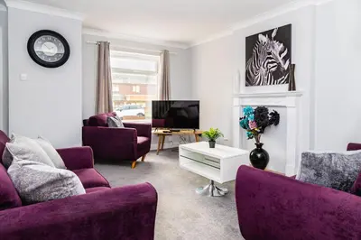 a living room with purple furniture and a tv at Mill Charm in Barrow in Furness